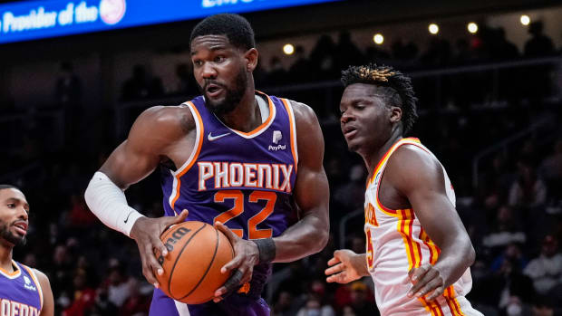 Deandre Ayton controls a rebound over Clint Capela.